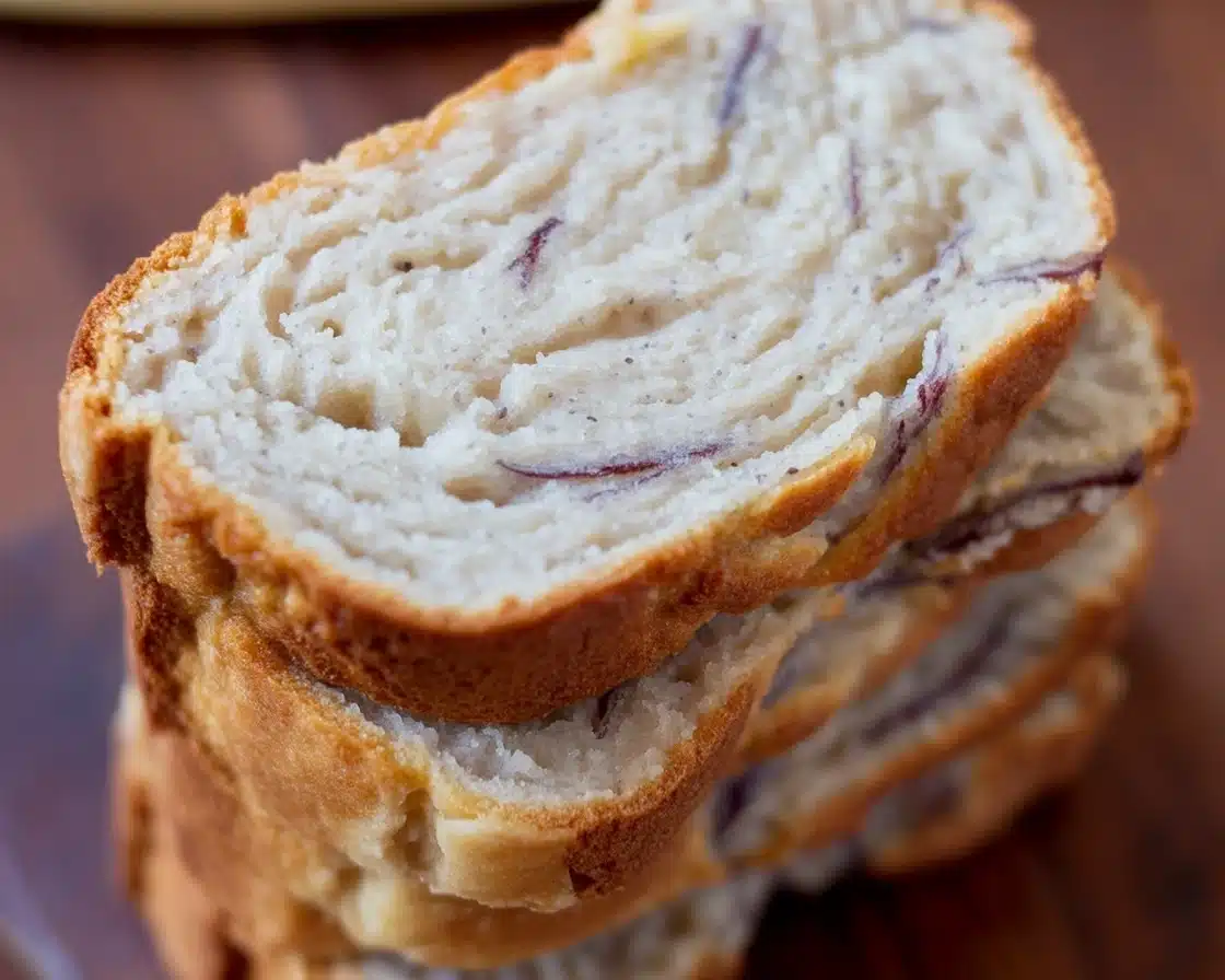 Moist gluten-free almond flour banana bread slice on a wooden table.